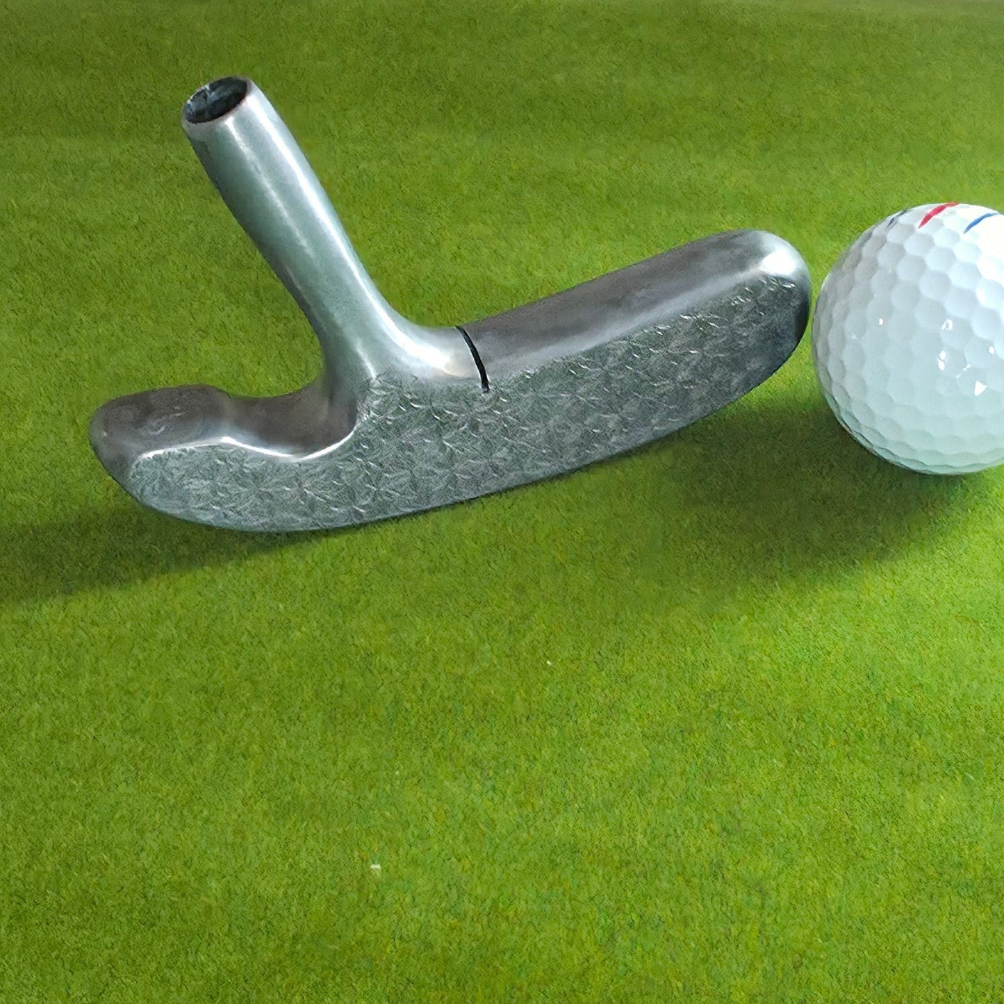 Golf ball on a green surface with a metal tee
