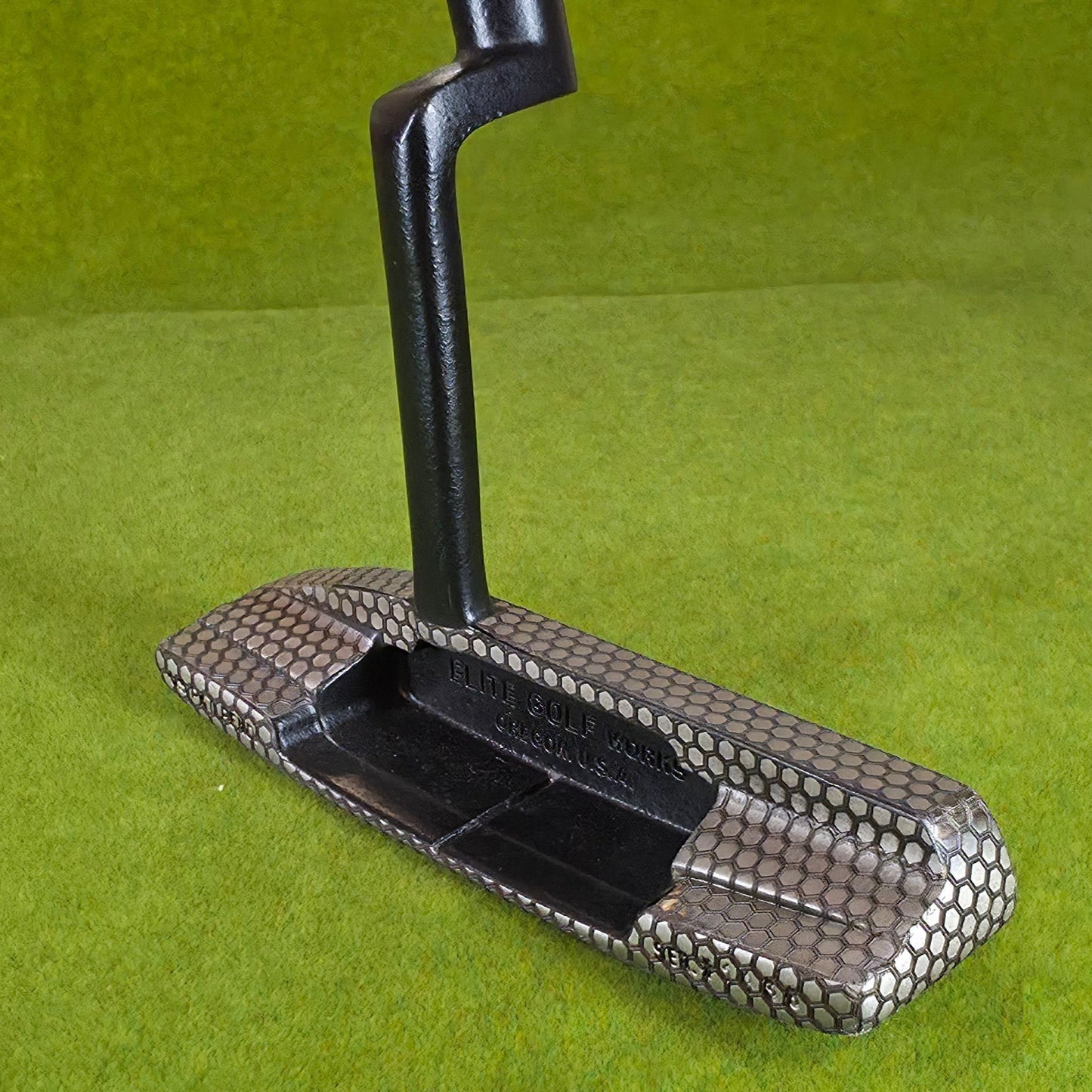 Metallic golf club head cover on a green background