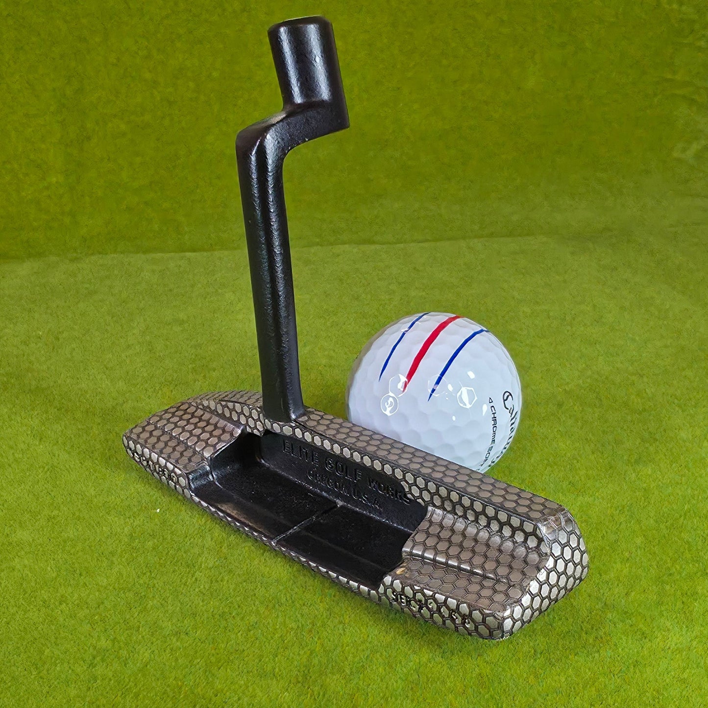 Golf club and ball on a green mat