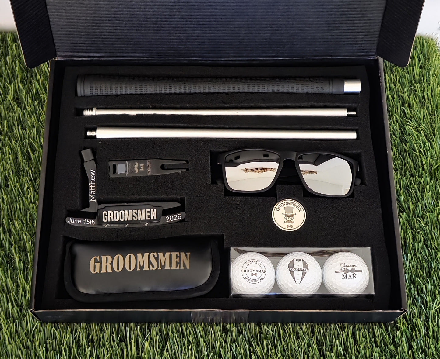 Groomsmen gift set with sunglasses, golf balls, and other items in a black box on grass.
groomsmen golf gift
personalized putter set
wedding party golf gift
custom golf gift for men
engraved groomsmen gift
last minute wedding gift
golf gift box for groomsman
bachelor party golf gift
groom gift for groomsmen
golf accessories gift set