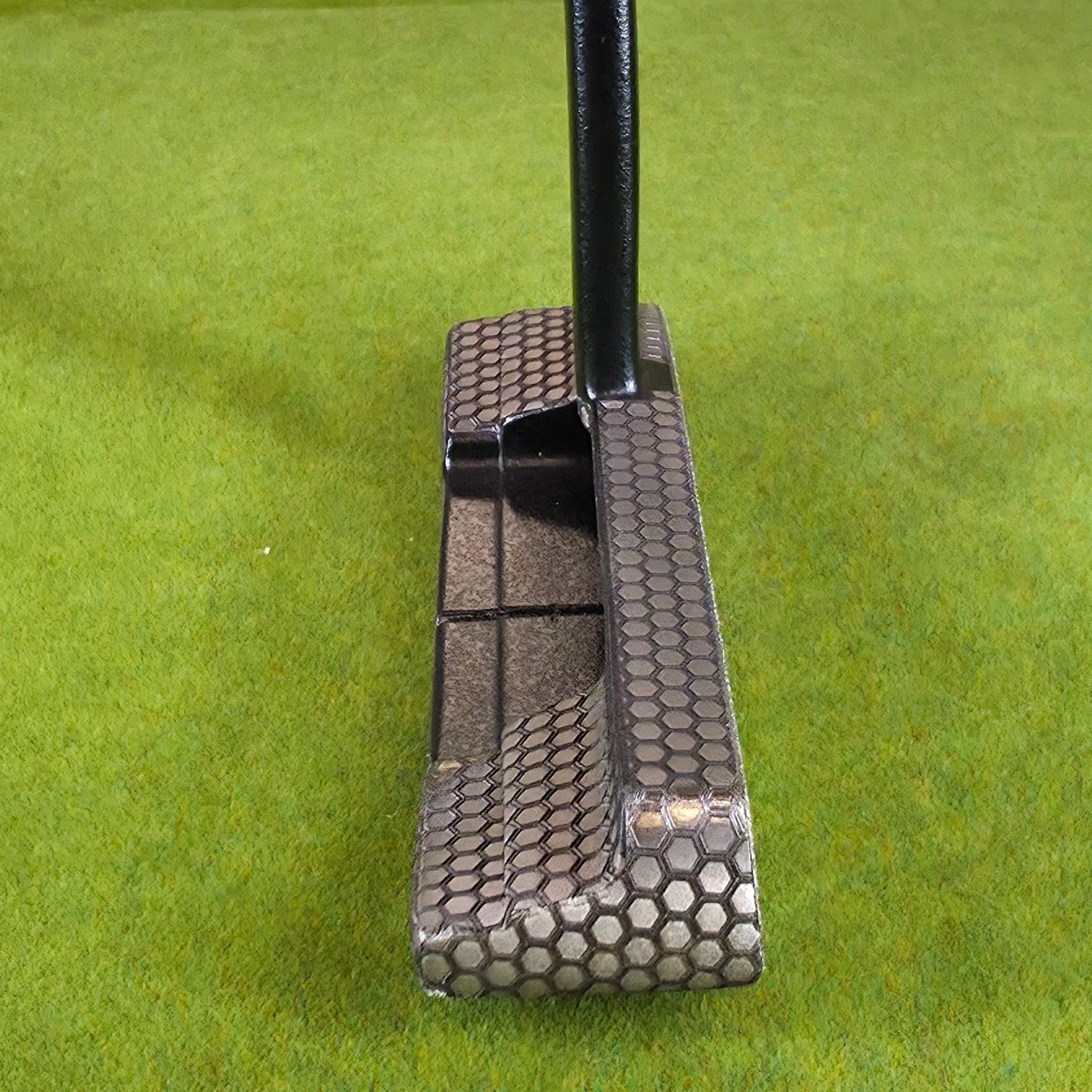 Golf putter on a green felt surface
