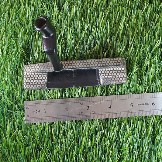 Golf club head, golf ball, and ruler on artificial grass