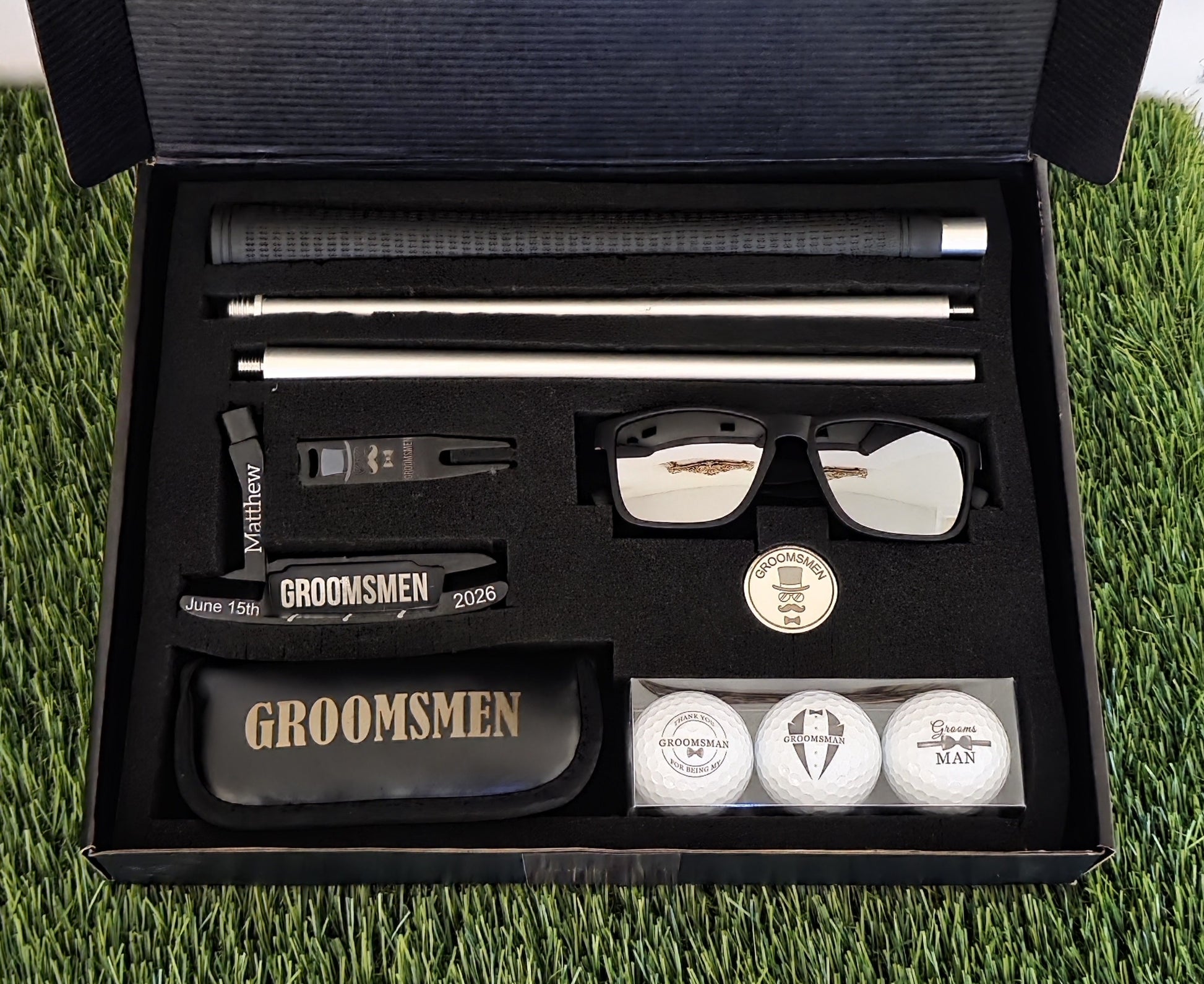 Groomsmen gift set with sunglasses, golf balls, and other items in a black box on grass.
groomsmen golf gift
personalized putter set
wedding party golf gift
custom golf gift for men
engraved groomsmen gift
last minute wedding gift
golf gift box for groomsman
bachelor party golf gift
groom gift for groomsmen
golf accessories gift set
