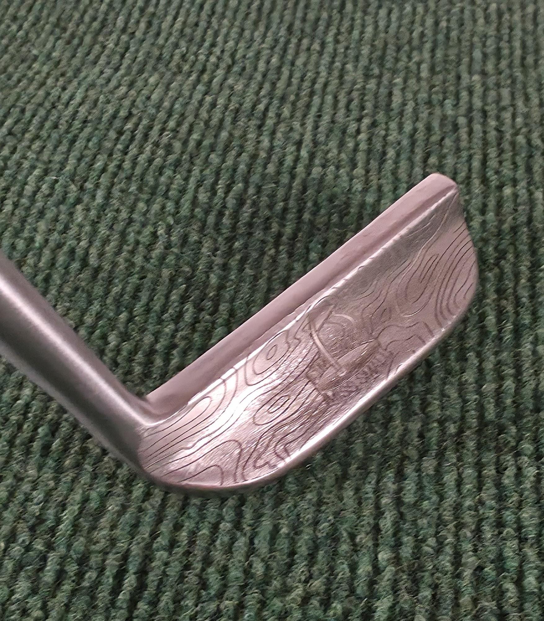 Custom engraved Cleveland Classic putter with topographic map design and “Aim Small Miss Small” phrase. Laser-engraved golf putter for players, collectors, and as a personalized golf gift. Features detailed circle pattern on the putter face for style and performance. Perfect for Father’s Day, birthdays, weddings, or retirement. A unique, functional Cleveland putter that combines artistry with accuracy. engraved golf putter cleveland golf club custom golf putter aim small miss small unique golf