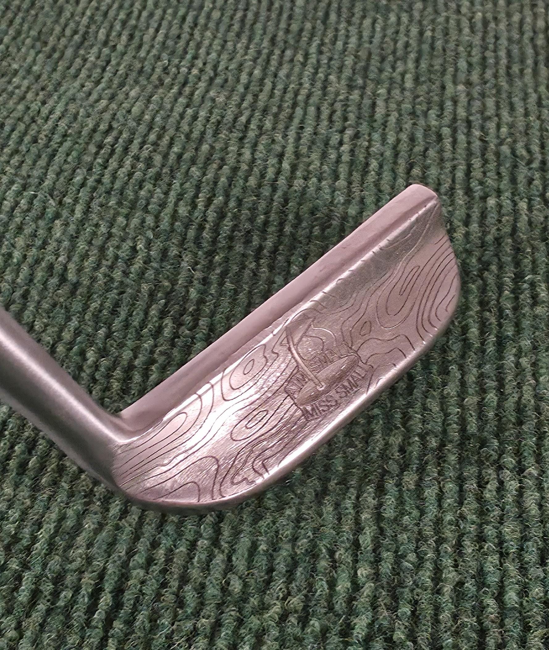 Custom engraved Cleveland Classic putter with topographic map design and “Aim Small Miss Small” phrase. Laser-engraved golf putter for players, collectors, and as a personalized golf gift. Features detailed circle pattern on the putter face for style and performance. Perfect for Father’s Day, birthdays, weddings, or retirement. A unique, functional Cleveland putter that combines artistry with accuracy. engraved golf putter cleveland golf club custom golf putter aim small miss small unique golf