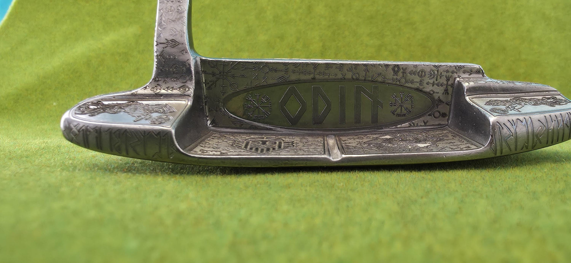 Custom hand-engraved Odin themed golf putter with Norse runes, Viking symbols, and raven designs. Features darkened engravings, raw steel finish, and detailed artwork on the face, back cavity, sole, and neck. Inspired by Norse mythology and Viking craftsmanship. Perfect for golf collectors or players who want a unique personalized putter.