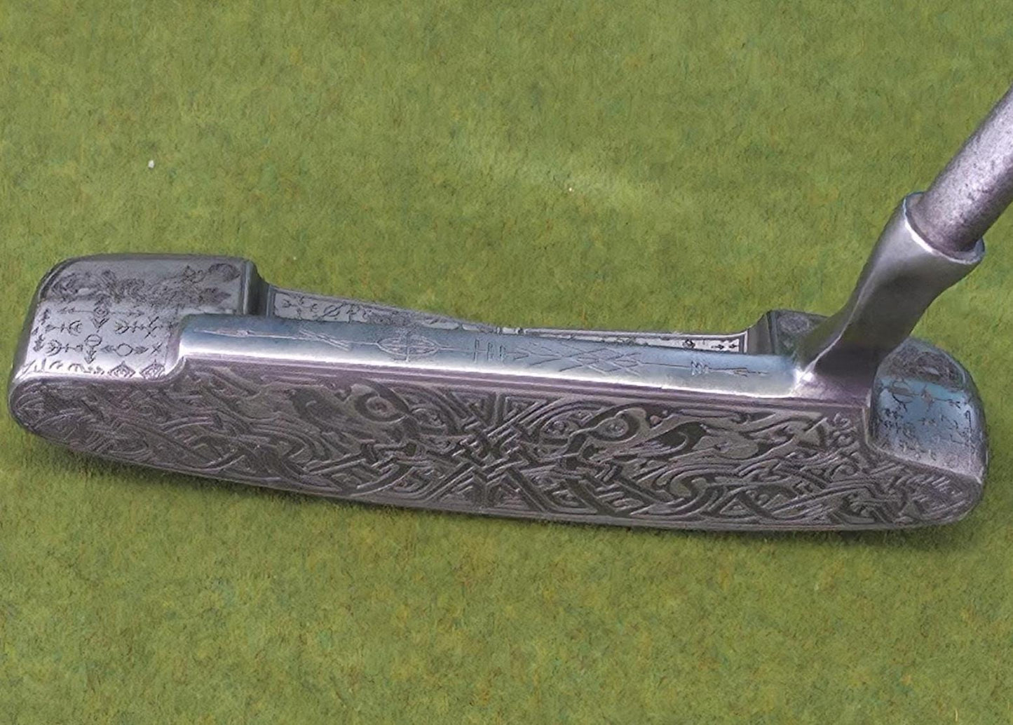 Custom hand-engraved Odin themed golf putter with Norse runes, Viking symbols, and raven designs. Features darkened engravings, raw steel finish, and detailed artwork on the face, back cavity, sole, and neck. Inspired by Norse mythology and Viking craftsmanship. Perfect for golf collectors or players who want a unique personalized putter.
