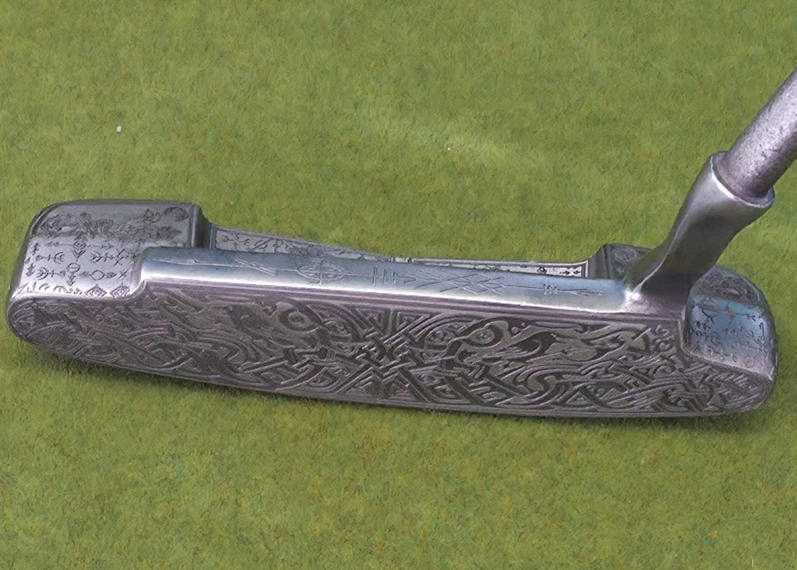 Custom hand-engraved Odin themed golf putter with Norse runes, Viking symbols, and raven designs. Features darkened engravings, raw steel finish, and detailed artwork on the face, back cavity, sole, and neck. Inspired by Norse mythology and Viking craftsmanship. Perfect for golf collectors or players who want a unique personalized putter.