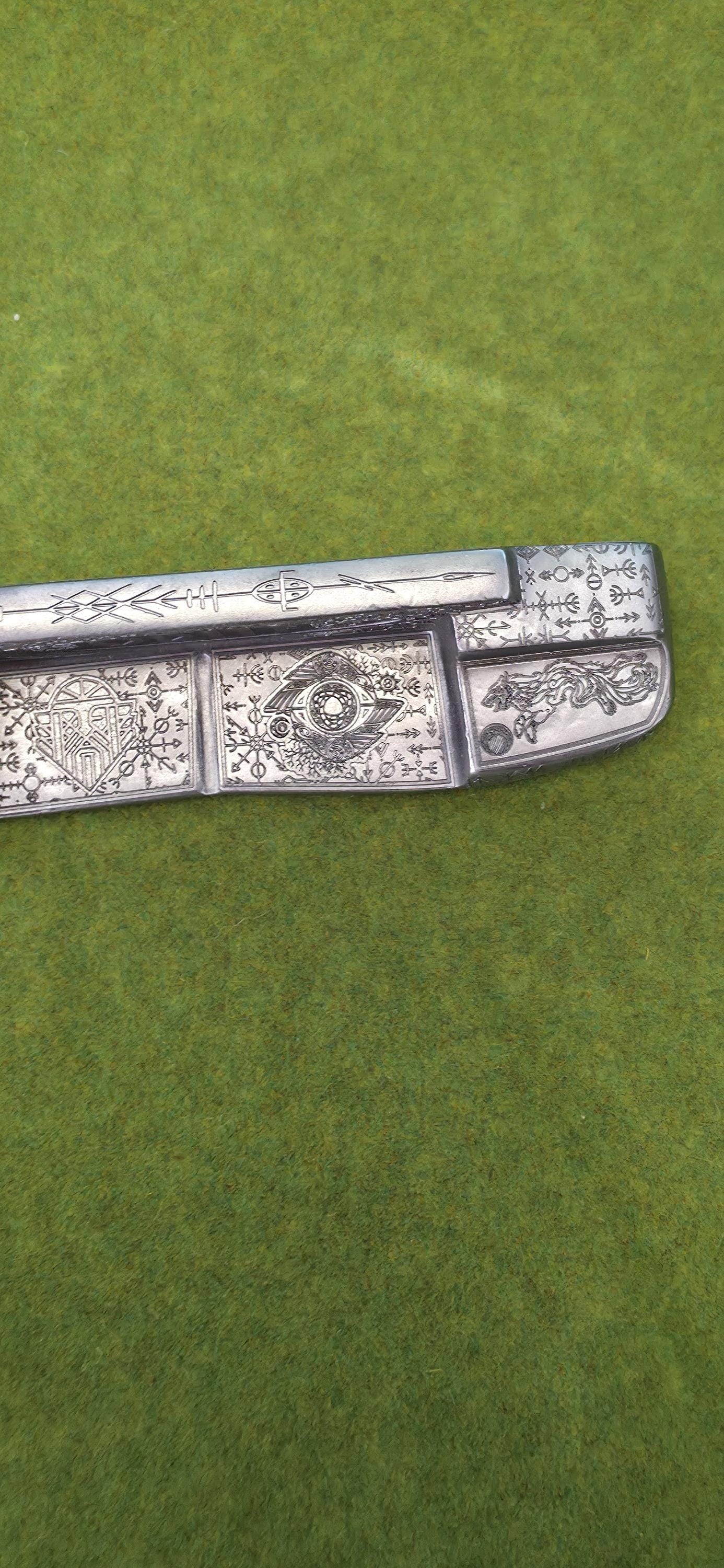 Custom hand-engraved Odin themed golf putter with Norse runes, Viking symbols, and raven designs. Features darkened engravings, raw steel finish, and detailed artwork on the face, back cavity, sole, and neck. Inspired by Norse mythology and Viking craftsmanship. Perfect for golf collectors or players who want a unique personalized putter.
