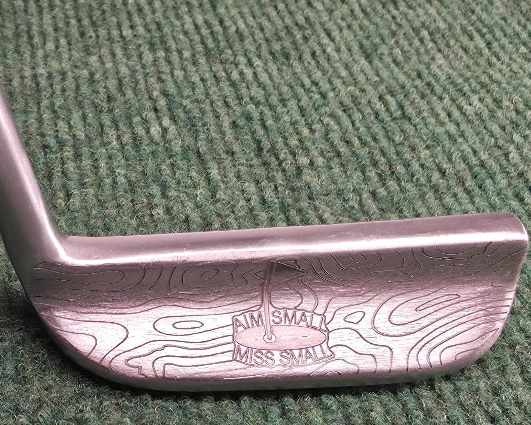 Custom engraved Cleveland Classic putter with topographic map design and “Aim Small Miss Small” phrase. Laser-engraved golf putter for players, collectors, and as a personalized golf gift. Features detailed circle pattern on the putter face for style and performance. Perfect for Father’s Day, birthdays, weddings, or retirement. A unique, functional Cleveland putter that combines artistry with accuracy. engraved golf putter cleveland golf club custom golf putter aim small miss small unique golf