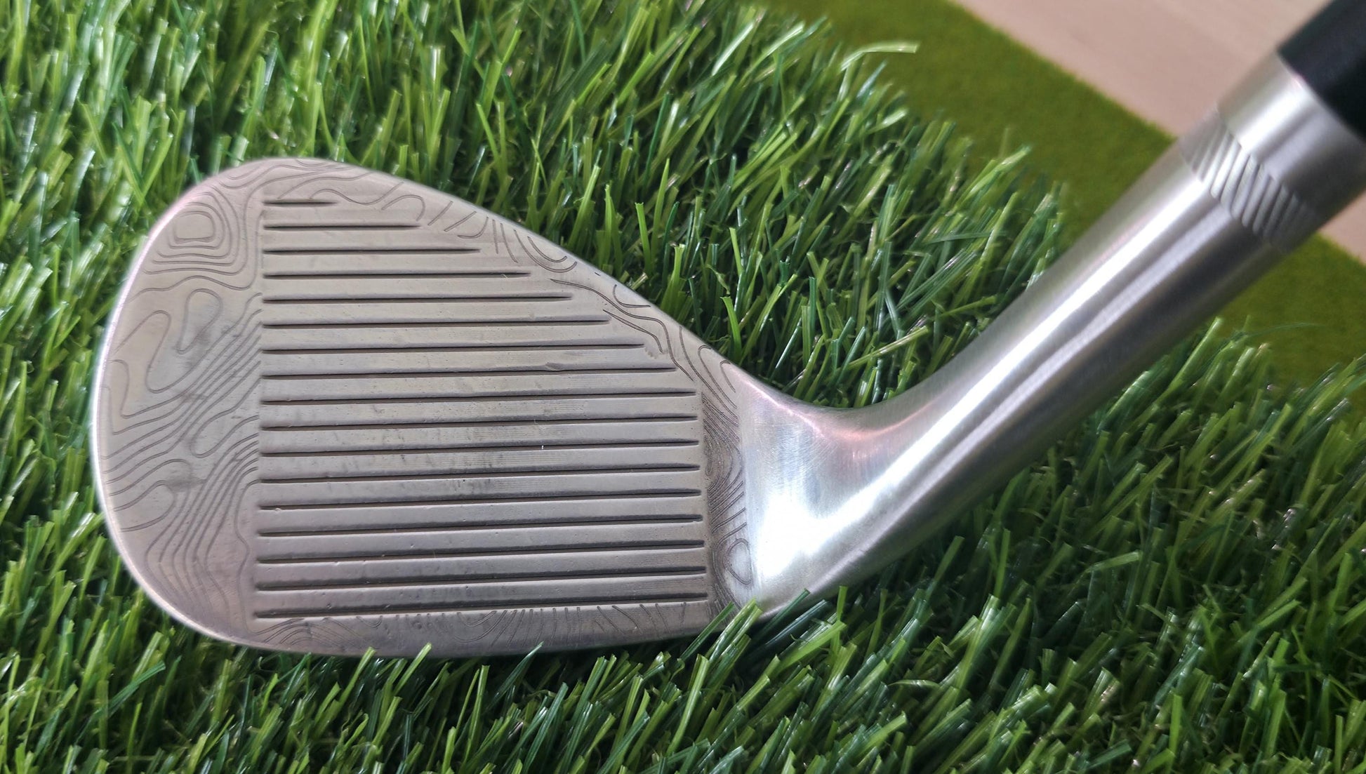 Custom laser-engraved Titleist Vokey SM8 golf wedge by Par Bros Golf, featuring a detailed, wrap-around topographic map pattern. The intricate artisan etching covers the steel clubhead, highlighting unique personalized craftsmanship. Titleist Vokey Design SM8 wedge with deep, intricate topographic map-style laser engraving covering the clubhead's surface. The 'BV' logo, 'SM8', and 'VOKEY DESIGN' markings are clearly visible on the brushed steel finish.