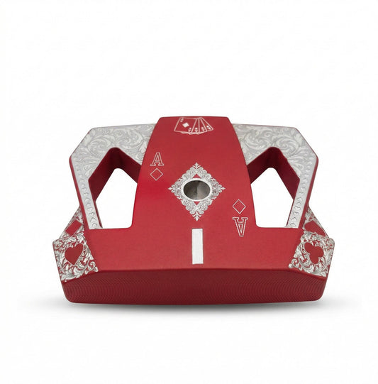 Detailed front view of a custom milled, deep matte red mallet putter head. Intricate playing card suit (Hearts, Diamonds, Spades, Clubs) engravings in satin silver. Features a fanned card graphic, "Ace of Diamonds" symbols, central hole, and center alignment aid. Engraved hearts on corners. ngled top-down view of a custom red mallet putter head resting on green artificial turf, showing the detailed silver scrollwork wings with small suit symbols.