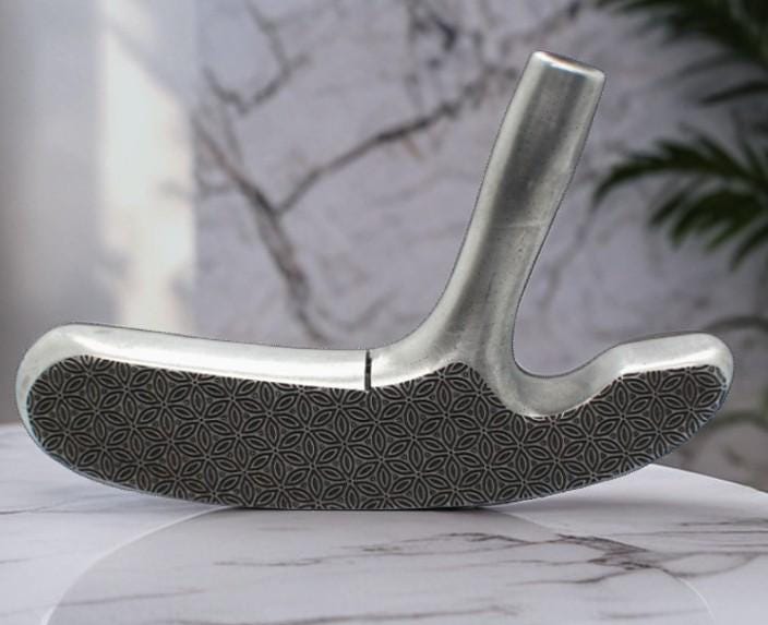 May include: A silver-colored golf club putter with a patterned grip. The putter is angled slightly, showcasing its design and the texture of the grip. The club is set against a marble-like surface.